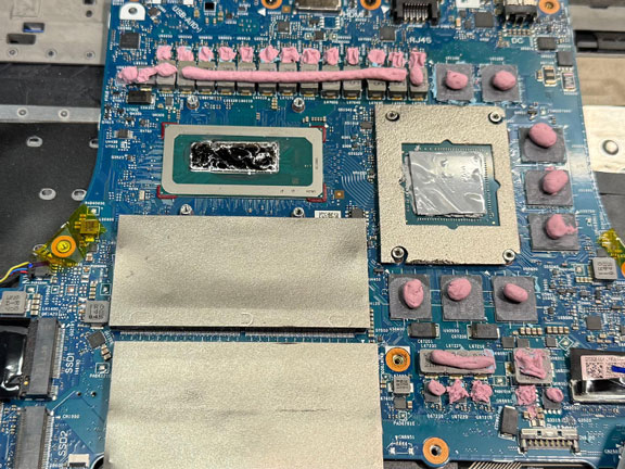 Gaming laptop thermal service with new thermal putty applied to motherboard components