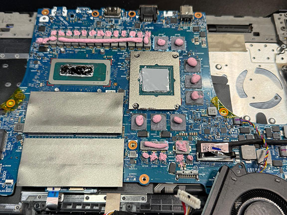 Gaming laptop motherboard with upgraded thermal putty applied to VRMs and chips